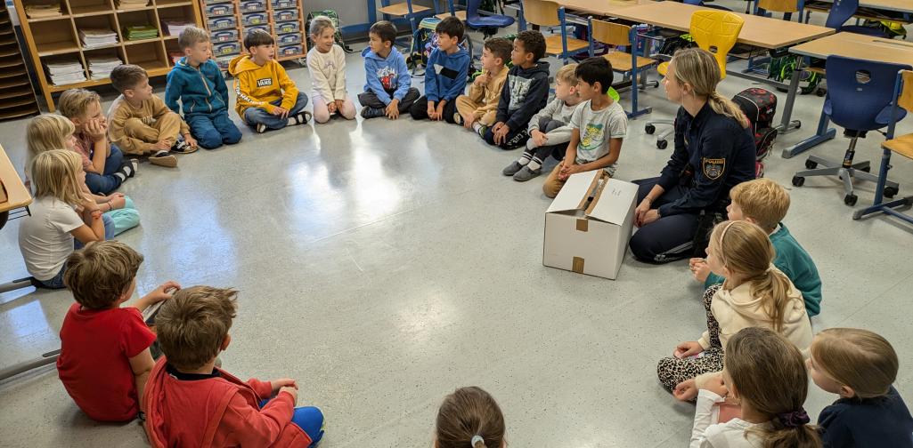 1. Klasse mit Polizistin im Sitzkreis